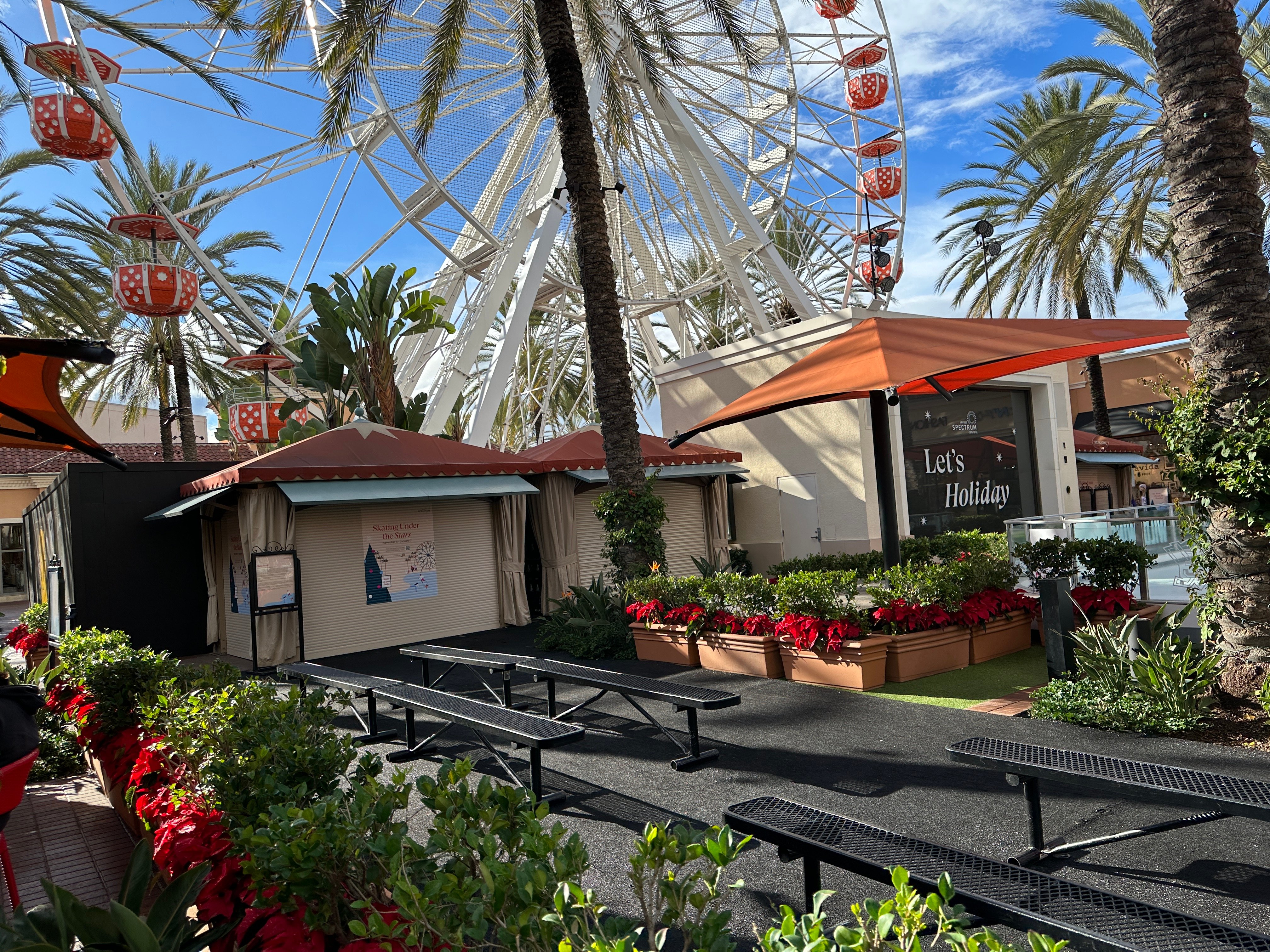The Giant Wheel rising over palm trees and the seasonal skating rink at Irvine Spectrum Center